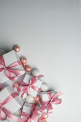 White gifts with pink ribbons. Set of gift box isolated on white background.Christmas gift boxes on white background. Beautiful Christmas background with shiny balls and ribbons in pastel pink color. 