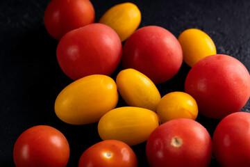 Mini red and yellow cherry tomatoes. Tomatoes on dark background.