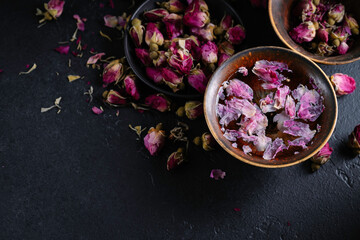 Obraz na płótnie Canvas Cup of roses tea with rose buds on dark background. Tea with rose.