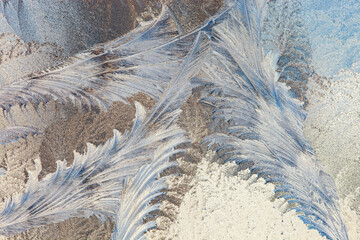 Frost forms in patterns on window glass on a cold winter morning