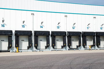 Row of loading docks with shutter doors at an industrial warehouse.