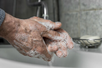 retired man washing wrinkled hands with soap gel prevention coronavirus concept