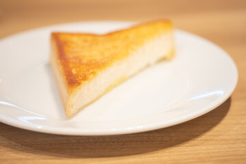 Triangle of garlic bread on white dish