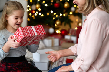 Grandma giving her granddaughter a Christmas gift