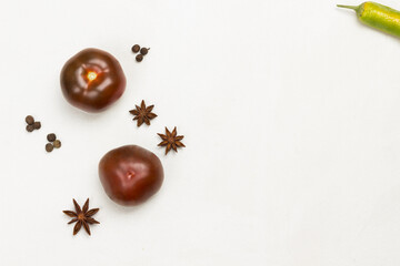 Fototapeta na wymiar Two tomatoes and spices, star anise, peppercorns.