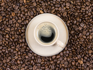 a cup of coffee on the background of coffee beans. View from above