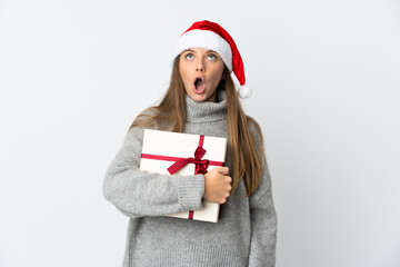 Lithianian woman with christmas hat holding presents isolated on white background looking up and with surprised expression