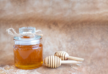 Glass can full of honey and wooden stick