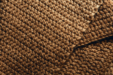 Brown knitted fabric close up. Fabric texture or background