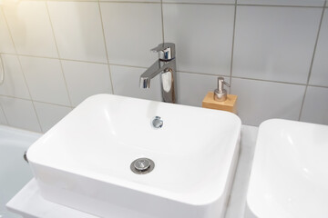 Modern bathroom interior with metal faucet and ceramic white sink.