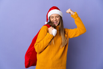 Lithianian woman with christmas hat isolated on purple background doing strong gesture