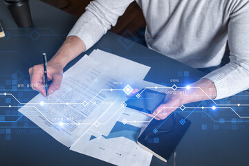 Double exposure of man signing contract with phone and technology hologram drawings. Concept of...