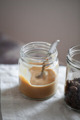 Coffee-flavored yogurt pudding dessert in glass jar on wooden table. Healthy lifestyle, superfood