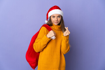 Lithianian woman with christmas hat isolated on purple background making money gesture