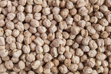 Closeup of a plate full of raw white chickpeas
. Organic textures as a background. Vegan food.