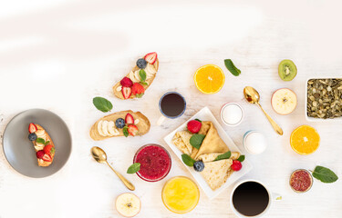 Family breakfast with delicious desserts, berries, pancakes and aromatic coffee. Overhead view of a flat plan