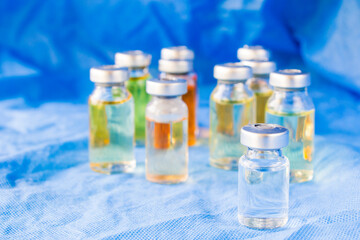 Corona virus and Covid - 19 new vaccine in ampules, different color variations of vaccine