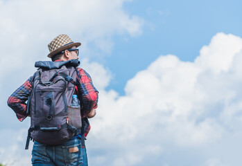 A young man traveler with backpack walking travel in the forest..