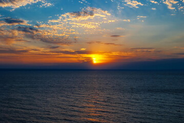 Bright sunset sky with beautiful clouds above water