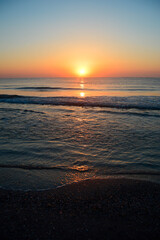 Fototapeta na wymiar Beautiful summer sunset at the beach, waves and sand