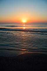 Beautiful summer sunset at the beach, waves and sand