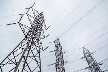 Low angle shot of high voltage powerlines on a gloomy day background