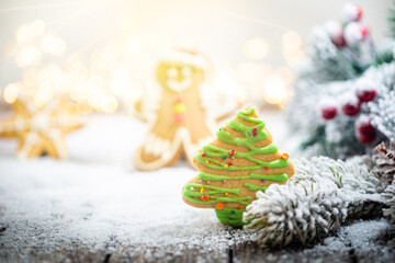 Christmas decorations on snow with gingerbread, fir tree branches and christmas lights. Winter Decoration Background