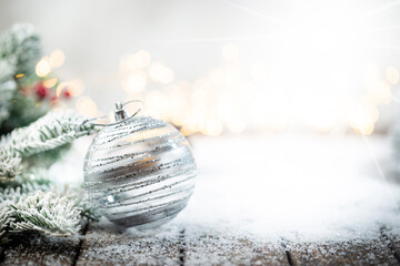 Christmas decorations on snow with christmas balls, fir tree branches and christmas lights. Winter Decoration Background with copy space for text