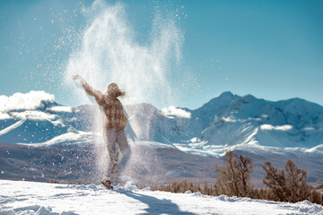 Fototapeta na wymiar Happy girl tossing powder snow in mountains