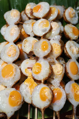 focus on Popular Thai street food,  Fried quail eggs served on a skewer known as khanom krok nok...