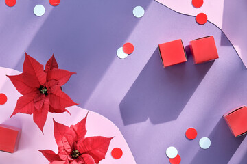 Christmas festive background. Striking red decorations on two tone lavender paper, organic shapes.