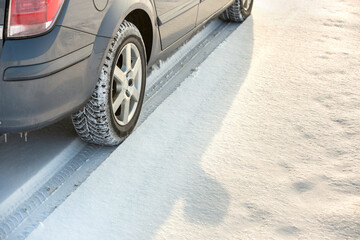 Fototapeta na wymiar Close-up of car wheels rubber tire in deep snow. Transportation and safety concept.
