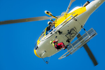 A member of a rescue group is hoisted by the helicopter crane