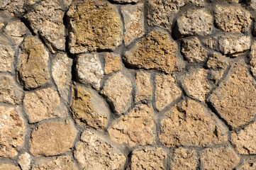 An uneven wall of decorative stacked cobblestones. Medieval background decorative insert