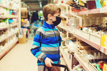 Child wearing a face mask in the store. Shopping time with kid during coronavirus outbreak.