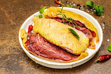 Raw duck breasts with fresh greens and fragrant spices