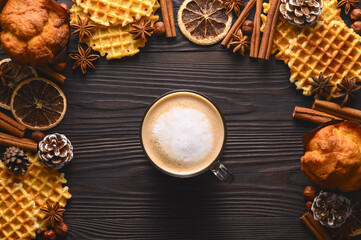 Cup of hot coffee, cookies and spices on wooden rustic background. Stylish cozy winter flat lay. Seasonal holidays concept. Top view