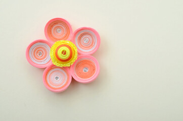 Quilling of paper flower on gray background