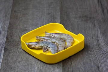 fresh raw shrimp sliced on square plate  on wood, wooden background,set shabu, hot pot ingredients.