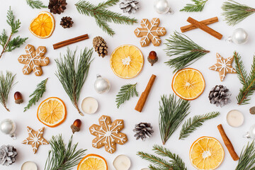 Christmas, winter, new year composition. Pattern made of Fir tree branches, pine cone, dried oranges, cinnamon sticks, gingerbread, candles on white background. Flat lay, top view, copy space