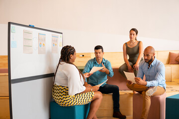 Lovely black business woman handing reports at meeting in office or coworking space. Communication,...