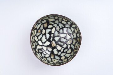 Black coconut shell bowl with pearl seashell pieces. Culinary, dishes concept. Top view, flat lay, copy space