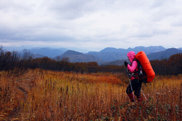 Hiker woman makes a walk in the mountains of Kamchatka