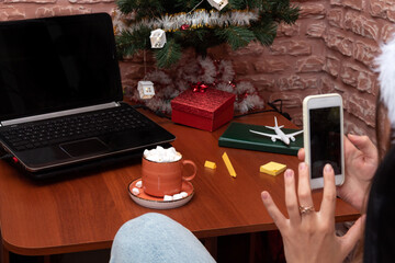 Freelancer's workplace during the new year period, hand with the phone. Selective focus.