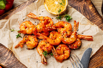 Delicious roasted shrimps on plate with lemon