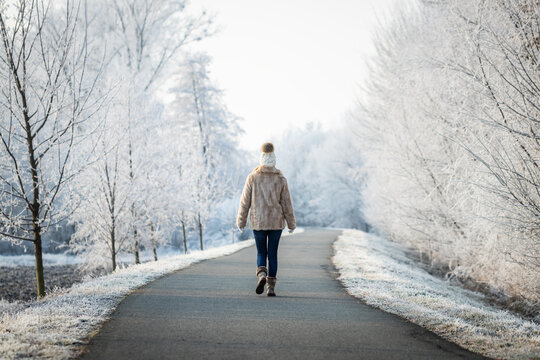 Woman Walking On Path In Park At Winter