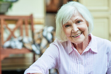 Smiling elder female posing at camera outside