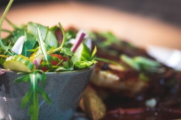 A pan fried chicken breast covered in sweet chilli sauce,  served with triple cooked chips and a side salad, garnished with spring onions and chilli.