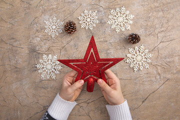 Christmas star decor in a woman's hand. Christmas and New year greeting card concept. Vintage style.