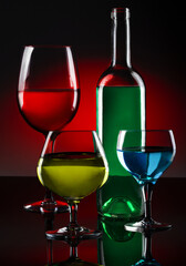 Set of crystal glasses with liquids of different colors on the table in the photo studio.